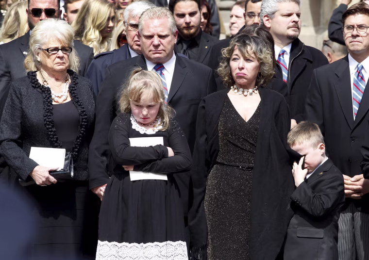 Image: Renata Ford, her daughter Stephanie and son Doug Ford Junior stand outside St James Cathedral with Doug Ford and his mother as the hearse leaves carrying former mayor Rob Ford, in Toronto