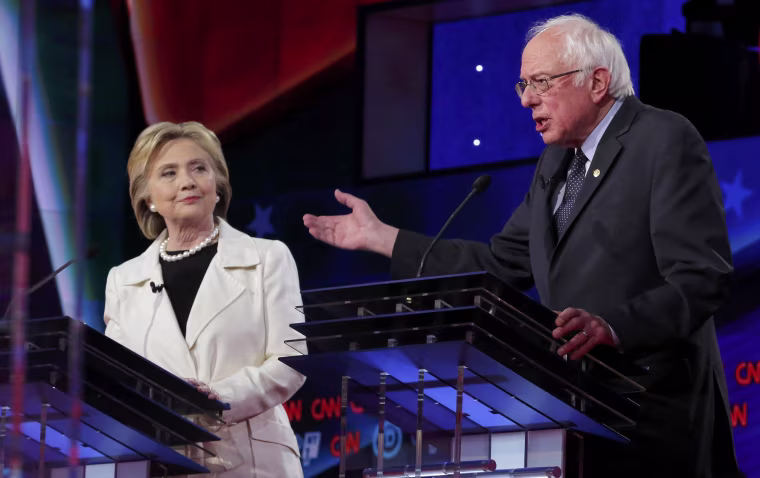 Image: Democratic U.S. presidential candidate Clinton listens to Sanders speak during a Democratic debate in New York