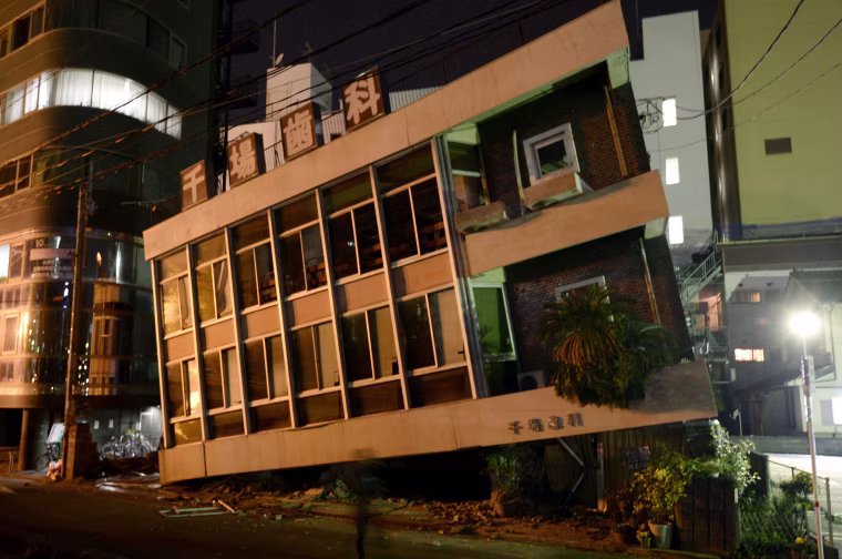 Image: A severely damaged dentist office leans to one side following an earthquake
