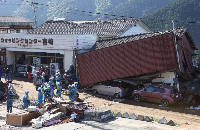 Image: Rescue workers try to save people from a collapsed house