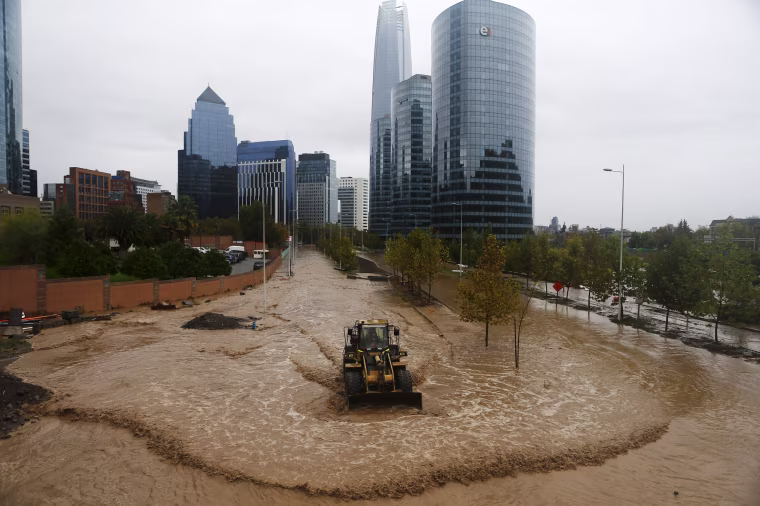 Image: A loader works on a flooded street in Santiago