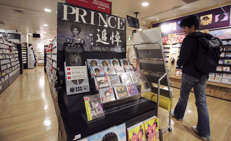 Image: A customer looks around a booth set up in memory of Prince at a music shop in Tokyo