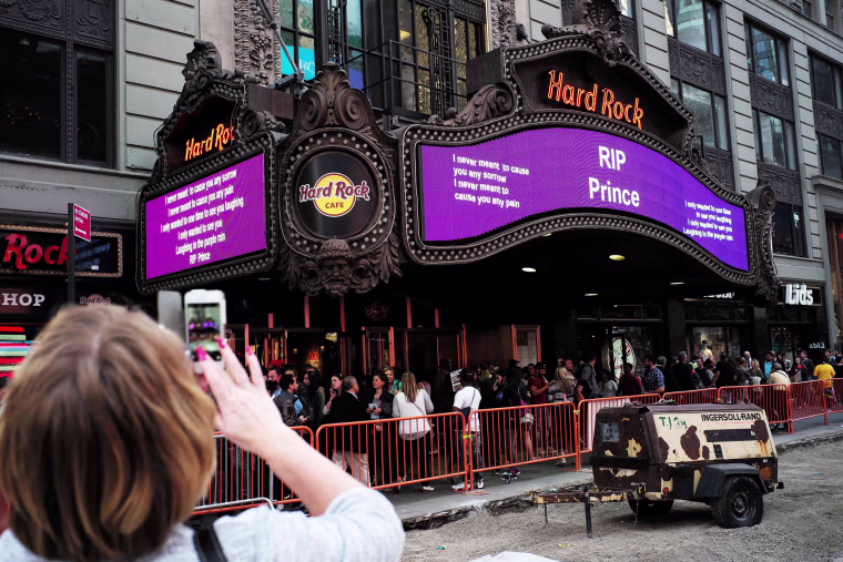 Image: A woman takes a picture of a tribute message in New York