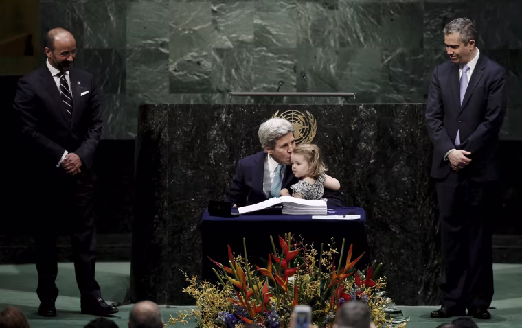 Image: U.S. Secretary of State Kerry holds his granddaughter as he signs the Paris Agreement on climate change at United Nations Headquarters in New York