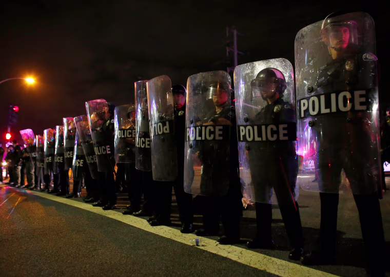 Image: Police in riot gear arrive to break-up a demonstration outside Republican U.S. presidential candidate Donald Trump's campaign rally in Costa Mesa
