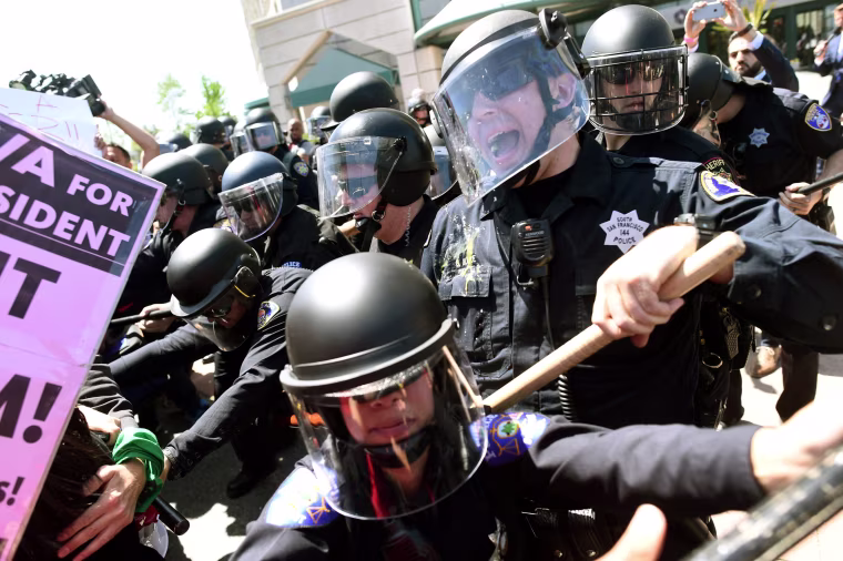 Image: Police in riot gear hold back demonstrators against Trump outside the Hyatt hotel where Trump is set to speak at the California GOP convention in Burlingame, California
