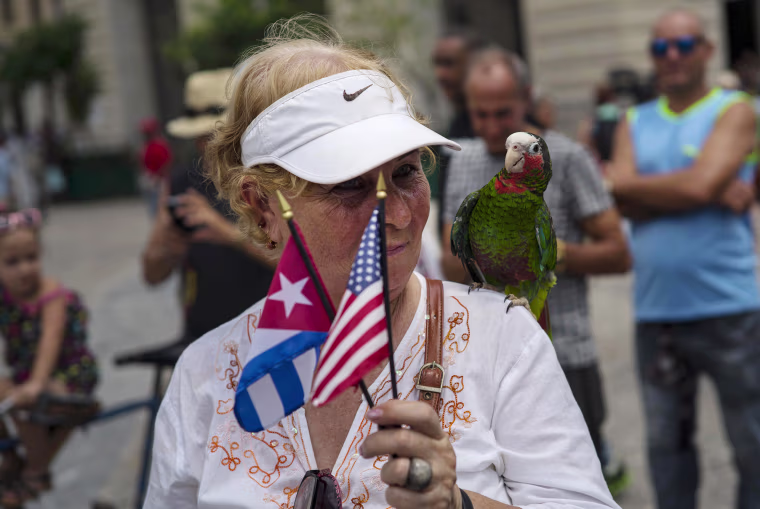 A cruise passenger poses for a photo with a parrot in Havana