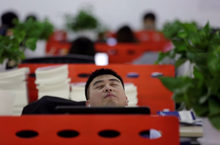 Image: The Wider Image: Working, eating and sleeping at the office