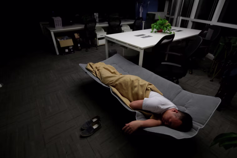 Image: The Wider Image: Working, eating and sleeping at the office