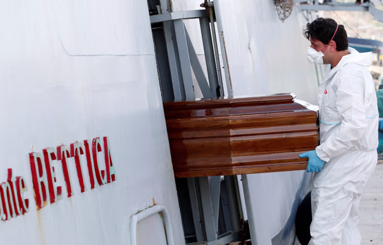 Image: A coffin containing a migrant is removed from Italian navy ships \"Bettica\" in the Sicilian harbour of Porto Empedocle