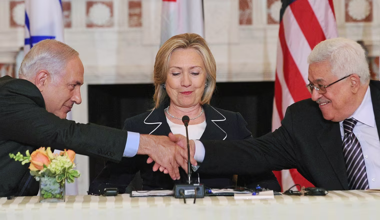 Image: US Secretary of State Hillary Clinton (C), looks on as Prime Minister Benjamin Netanyahu of Israel (L) and President Mahmoud Abbas of the Palestinian Authority (R) shakes hands as they re-launch of direct negotiations between Israeli and Palestinia