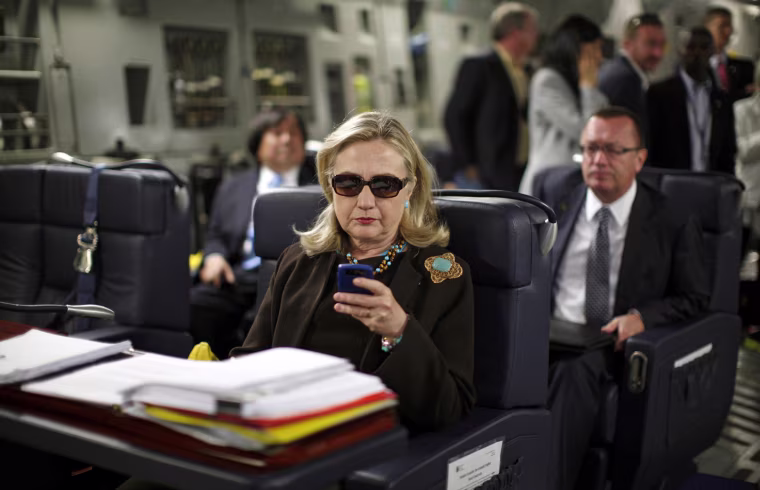 Image: U.S. Secretary of State Hillary Clinton checks her PDA upon her departure in a military C-17 plane from Malta bound for Tripoli, Libya