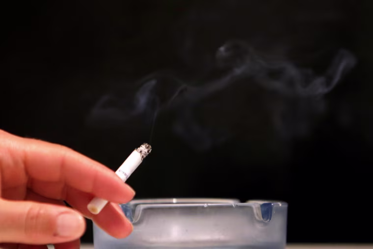 Image: A customer smokes a cigarette in a cafe