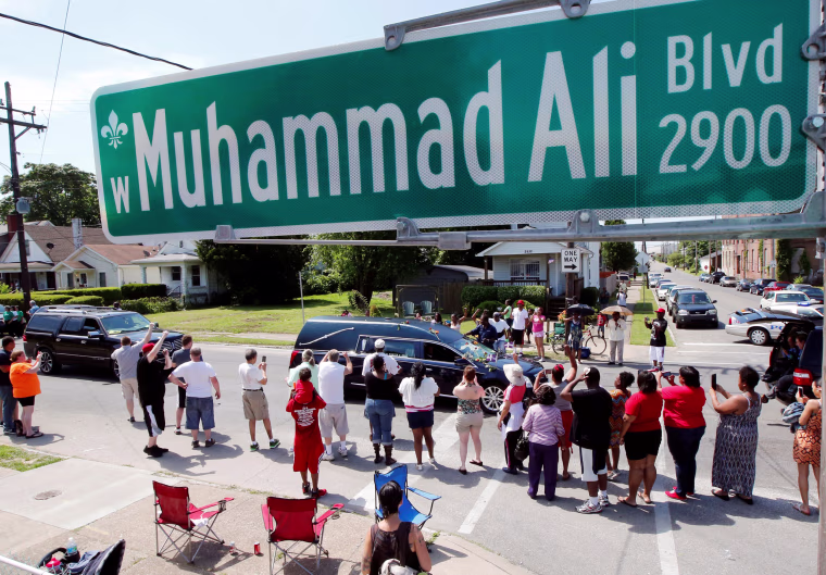Image: A hearse carrying the body of the late Muhammad Ali drives down Muhammad Ali Boulevard to Cave Hill Cemetery in Louisville
