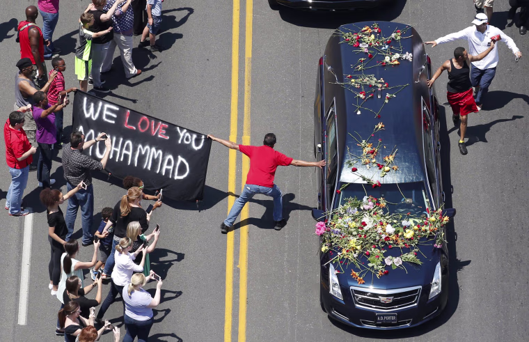 Image: Well-wishers touch the hearse carrying the remains of Muhammad Ali during the funeral procession in Louisville