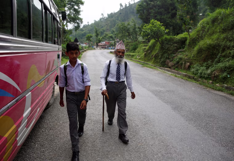 Image: Sagar Thapa, 14, walks with Kami as they head to school.