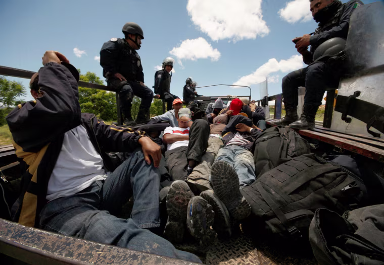 Image: Riot police officers keep watch next to protesters from the National Coordination of Education Workers (CNTE) teachers???????? union who were detained after clashing with the police, in Nochixtlan