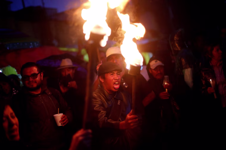 Image: A protester from the CNTE teachers' union holds a torch as he yells during a march following clashes in southern Mexico over the weekend between police and members of CNTE, in Mexico City