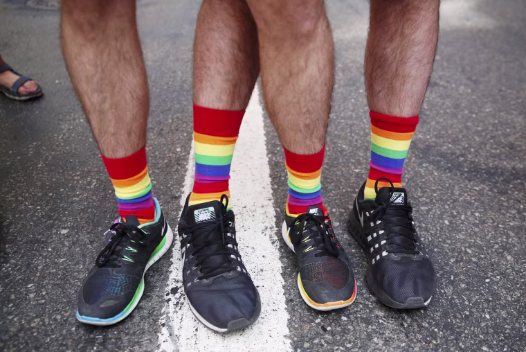 Image: People show colored socks as they take part in the annual NYC Pride parade in New York City