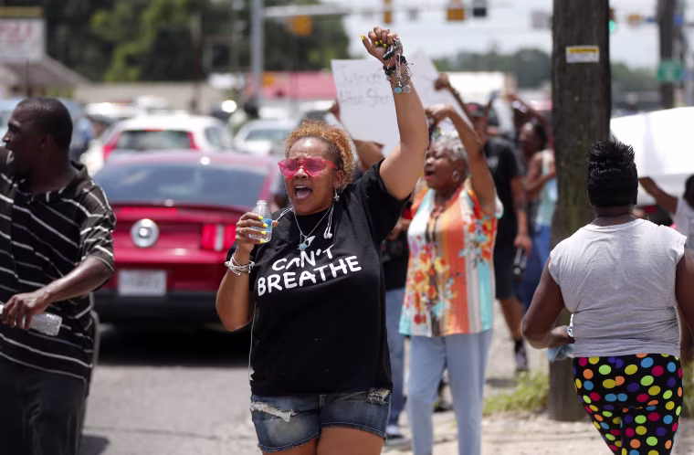 Image: People march outside the Triple S convenience store in Baton Rouge