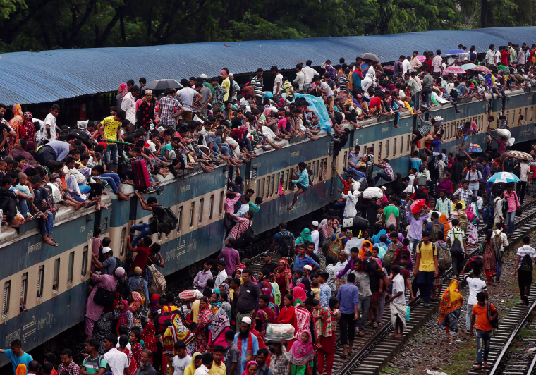 Image: People climb to board an overcrowded passenger train as they travel home to celebrate Eid al-Fitr festival, which marks the end of the Muslim holy fasting month of Ramadan, at a railway station in Dhaka