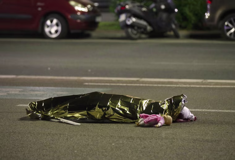 Image: A body is seen on the ground after at least 30 people were killed in the southern French town of Nice when a truck ran into a crowd celebrating the Bastille Day national holiday