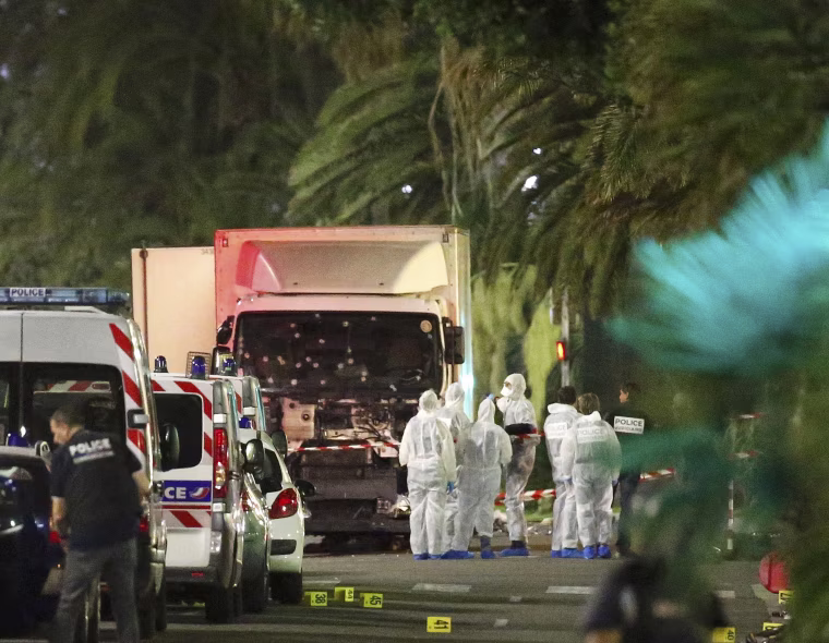 Image: French police forces and forensic officers stand next to a truck that ran into a crowd celebrating the Bastille Day national holiday on the Promenade des Anglais killing at least 60 people in Nice