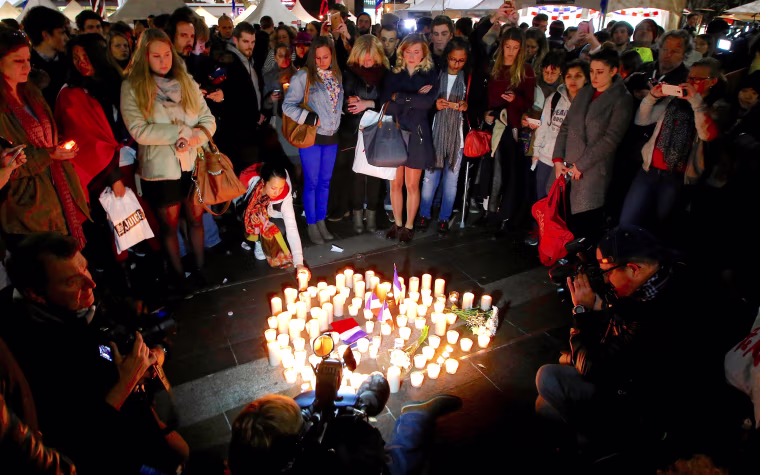 Image: Members of the Australian French community stand around candles during a vigil in central Sydney