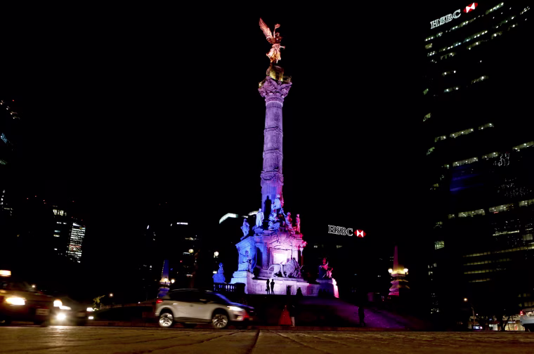 Image: The colours of the French flag are projected on the Angel of Independence monument in Mexico City