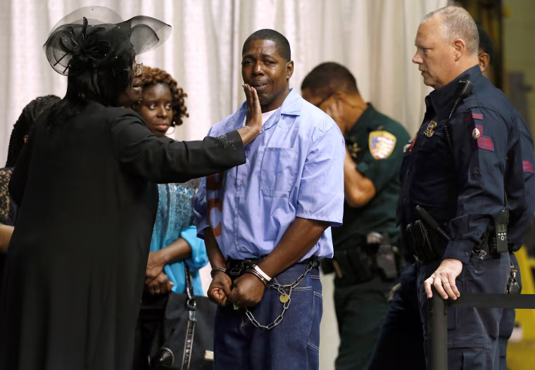 Image: An inmate with the Louisiana Department of Corrections is consoled by friends and family they attend the funeral of Alton Sterling, in Baton Rouge