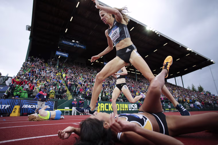 Image: Morgan Uceny, top, steps over Brenda Martinez at the finish line in the finals of the women's 1500-meter run