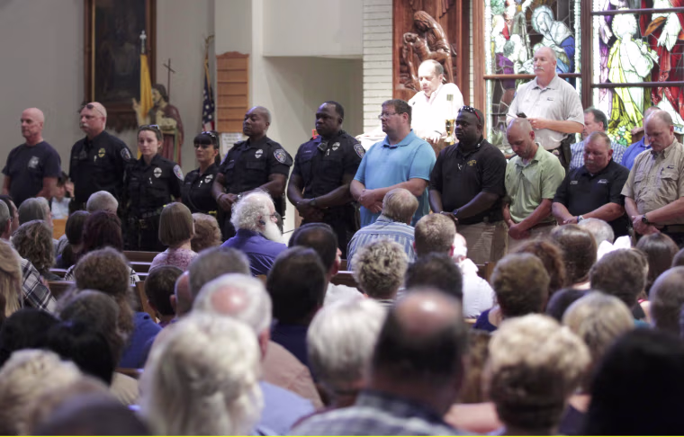 Image: Police officers attend a vigil after a fatal shooting of Baton Rouge policemen, at Saint John the Baptist Church in Zachary
