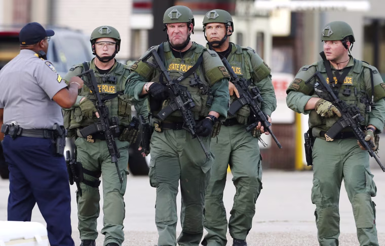 Image: Law enforcement personnel walk near the scene where police officers were shot in Baton Rouge