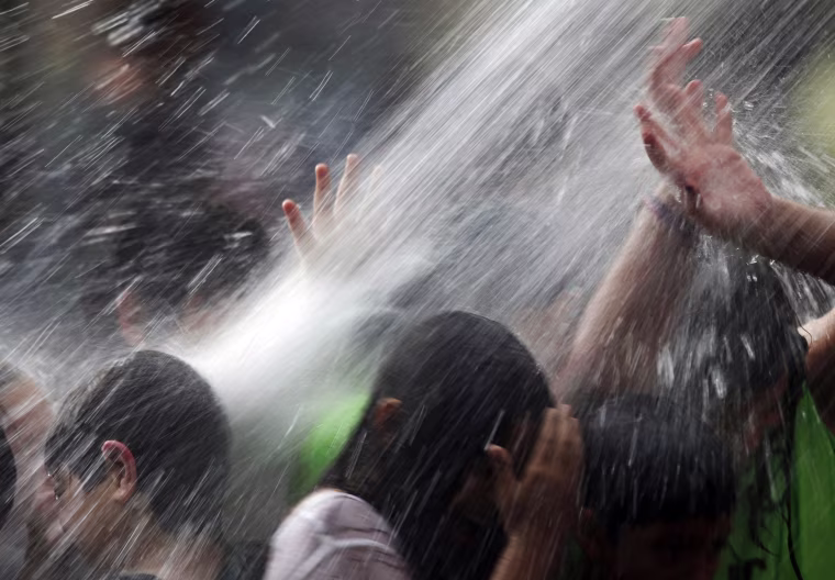 Children play in a water fall at the Crown Fountain in Chicago's Millennium Park, seeking temporary relief to the Midwest's excessive heat on July 21 in Chicago. The high pressure system, sometimes called a \"heat dome,\" will push conditions to their hottest point so far this summer, though record hot temperatures are not expected, according to the National Weather Service.