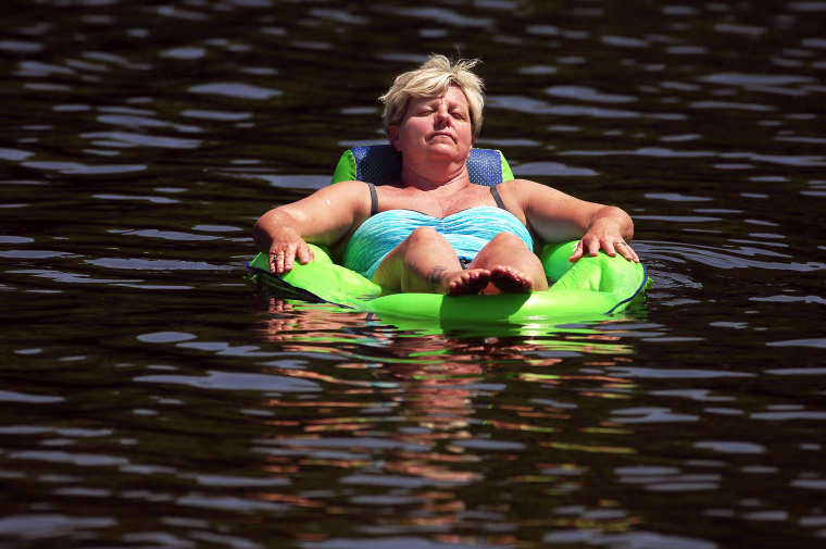 Patti Glessner, 52, of Cambridge, Md., relaxes on her raft at Keen Lake in Canaan Township, Pa.