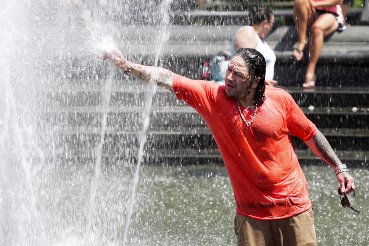 Image: A man cools off himself on a fountain during a heat wave called "Heat Dome" in the Manhattan borough of New York, U.S.