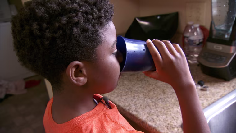 Quinn Bourgeois, 11, drinks a glass of water at his home in the Gentilly neighborhood of New Orleans. His family recently tested their water and found 11 parts per billion of lead coming through the kitchen tap.