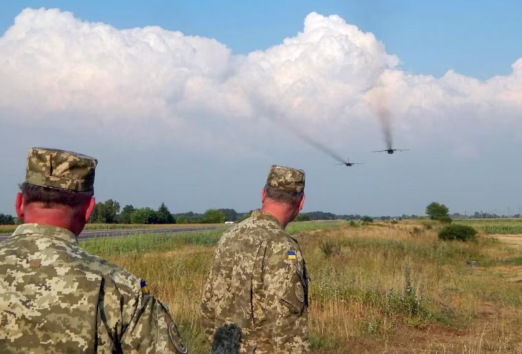 Image: Ukrainian servicemen watch Sukhoi Su-24 front-line bombers fly during military aviation drills as Russia accuses Ukraine in incursion into annexed Crimea, in Rivne region