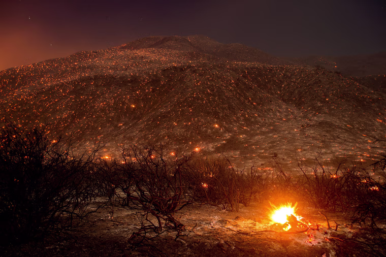 Image: Embers from a wildfire smolder along Lytle Creek Road near Keenbrook, Calif., on Aug. 17.