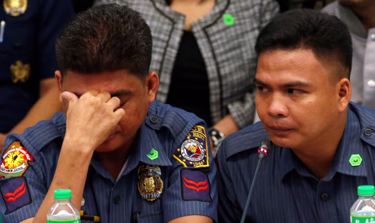 Image: Policemen accused of killing a couple during an illegal drugs raid testify at a Senate hearing in Manila, Tuesday.