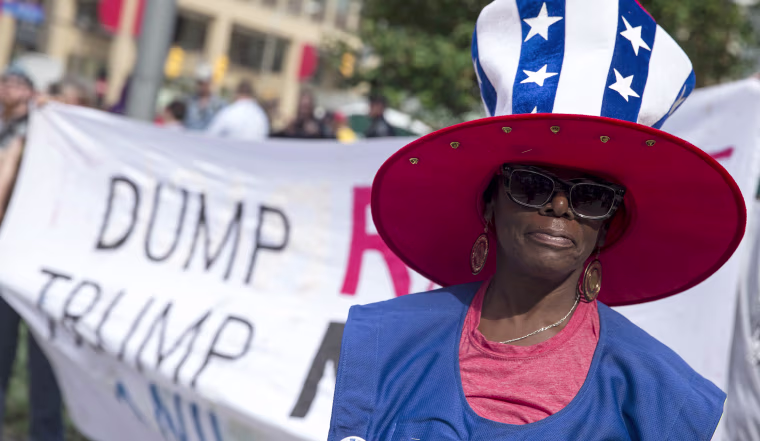 Image: A protester with the End Poverty Now rally marches through downtown Cleveland, the site of Republican National Convention.