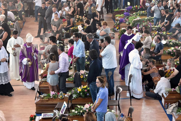 Image: People attend a funeral service for victims of the earthquake