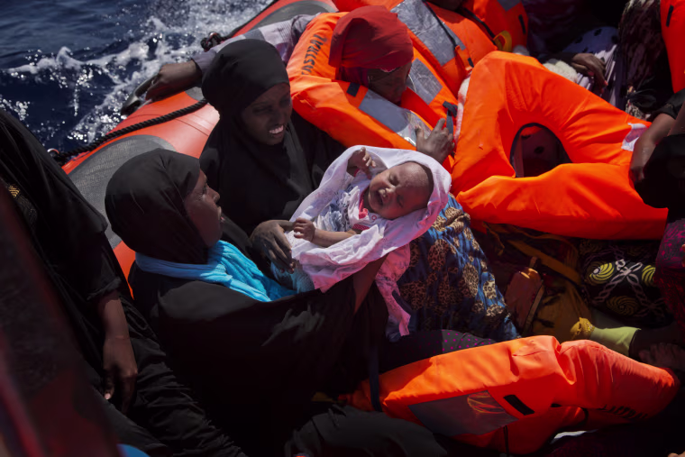 Image: Migrant women from Nigeria, one of them holding a baby, are rescued by emergency teams