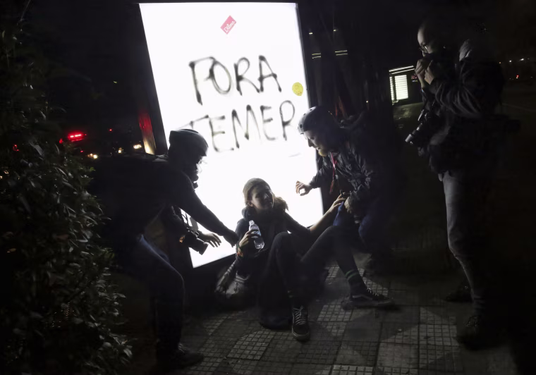 Image: Photographers help a woman who was affected by tear gas during a protest against Brazil's new President Michel Temer after Brazil's Senate removed former Dilma Rousseff in Sao Paulo