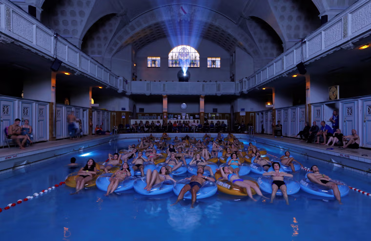 Image: People attend the screening of the film \"Jaws\" by director Steven Spielberg, screened at Strasbourg public baths during the European Fantastic Film Festival, in Strasbourg