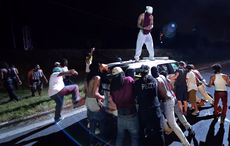 Image: Protesters surround a police vehicle in Charlotte