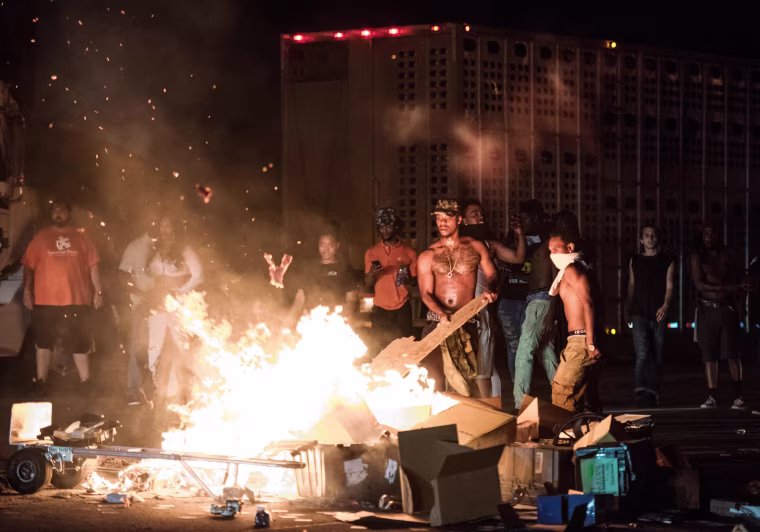 Image: People set cargo from tractor trailers on a fire on I-85 during protests