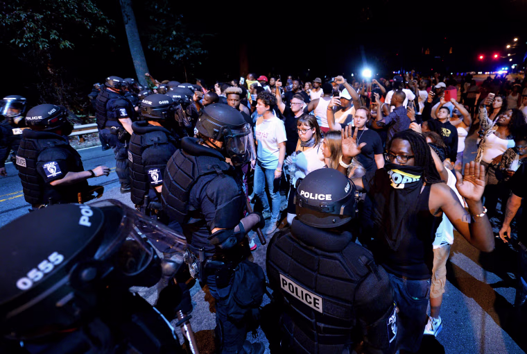 Image: Police officers form a line in front of protesters in Charlotte