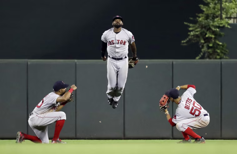 Image: Boston Red Sox outfielders celebrate after a baseball game