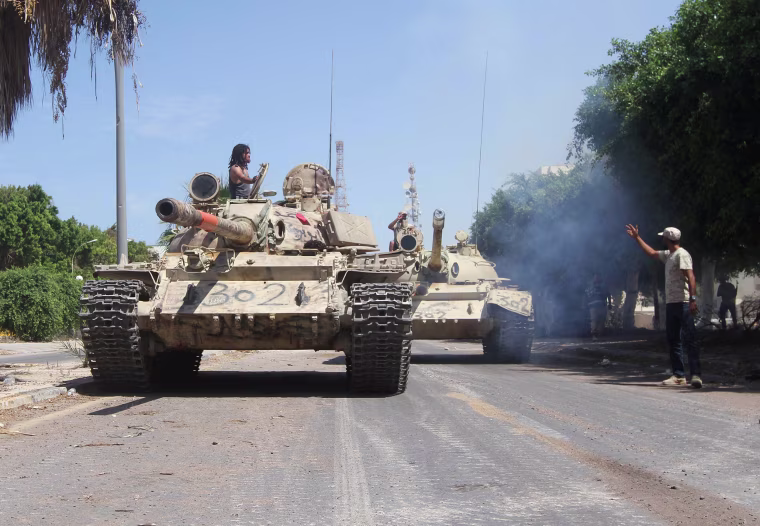 Image: Members of Libyan forces allied with the U.N.-backed ride their tanks during a battle with Islamic State militants in Sirte